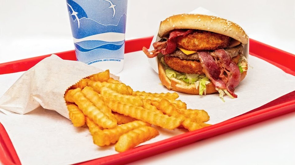 Menu board with burgers, fries, and sides.